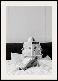 Black and white photo of woman in bathrobe reading newspaper in bed-2