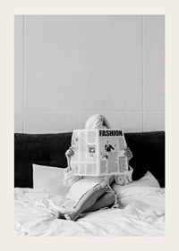 Black and white photo of woman in bathrobe reading newspaper in bed-3