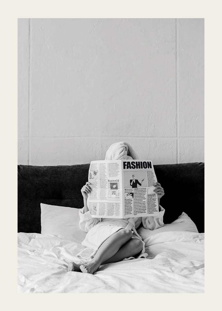 Fotografie alb-negru cu o femeie în halat de baie citind ziarul în pat-12