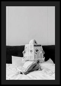 Black and white photo of woman in bathrobe reading newspaper in bed-4