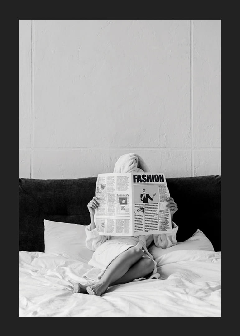 Fotografie alb-negru cu o femeie în halat de baie citind ziarul în pat-12