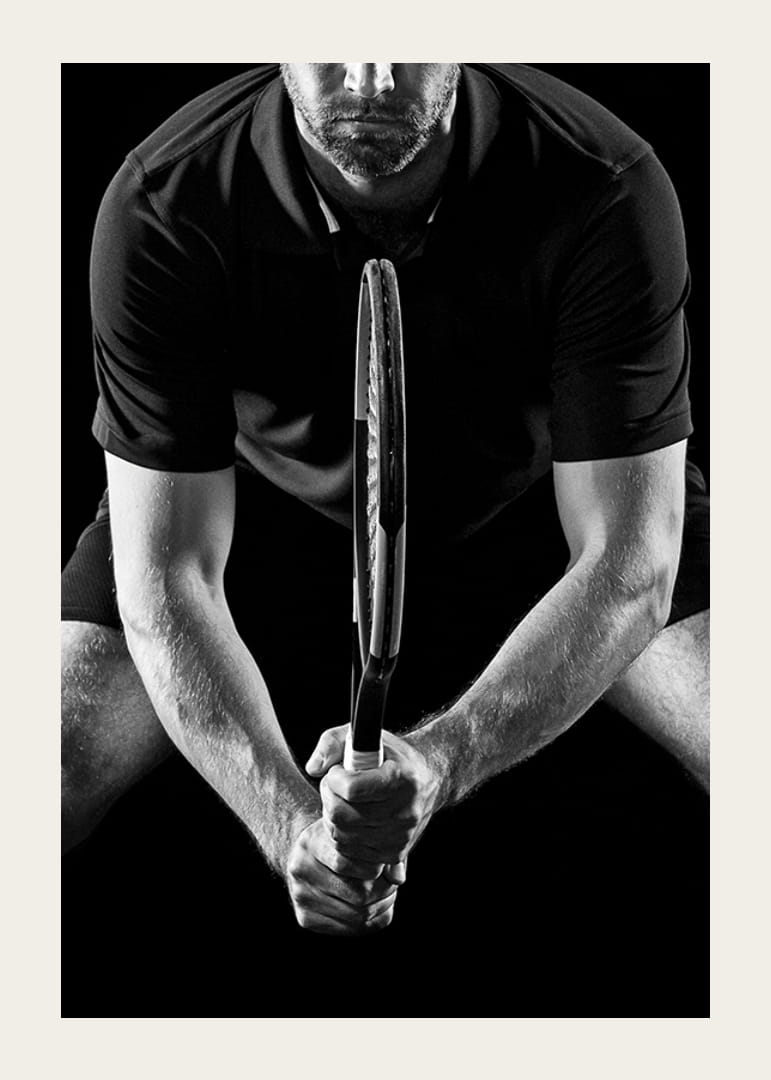 Svartvit närbild av tennisspelare med racket i fokus-12