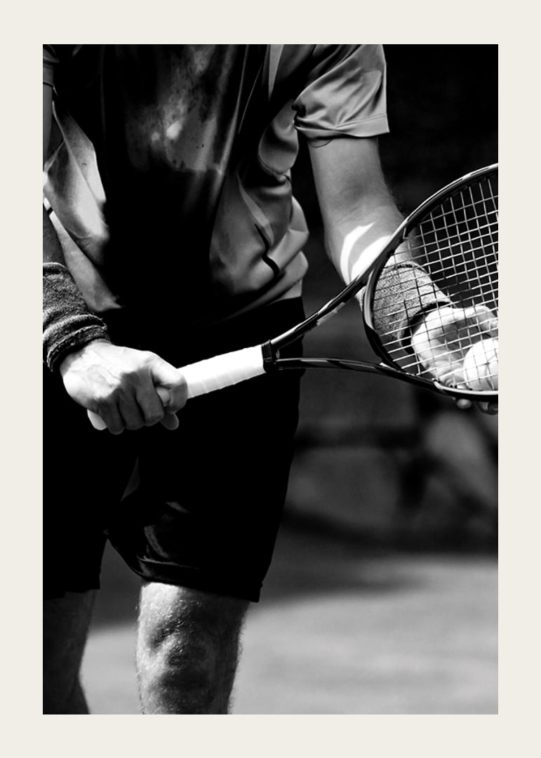Black and white photo of tennis player with racket and ball-12