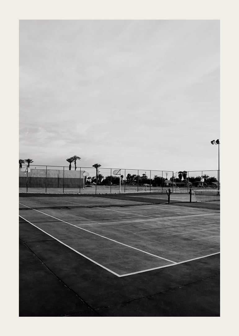 Svartvitt foto av tom tennisplan med linjer och palmträd-12