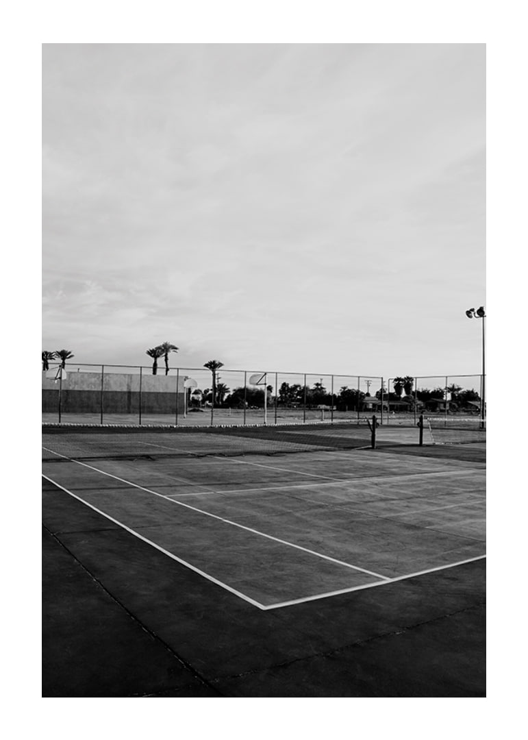 Svartvitt foto av tom tennisplan med linjer och palmträd-12