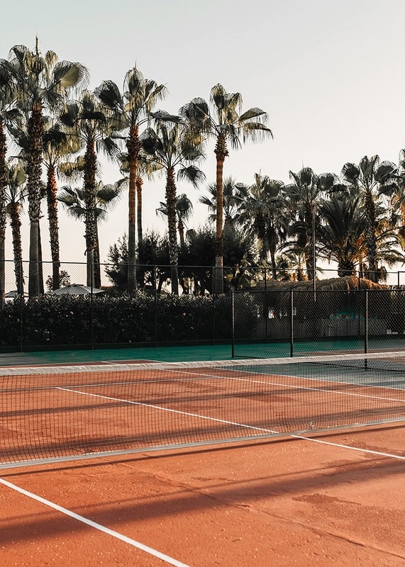 Fotografisk tennisplan med röda toner och palmer i bakgrunden-12