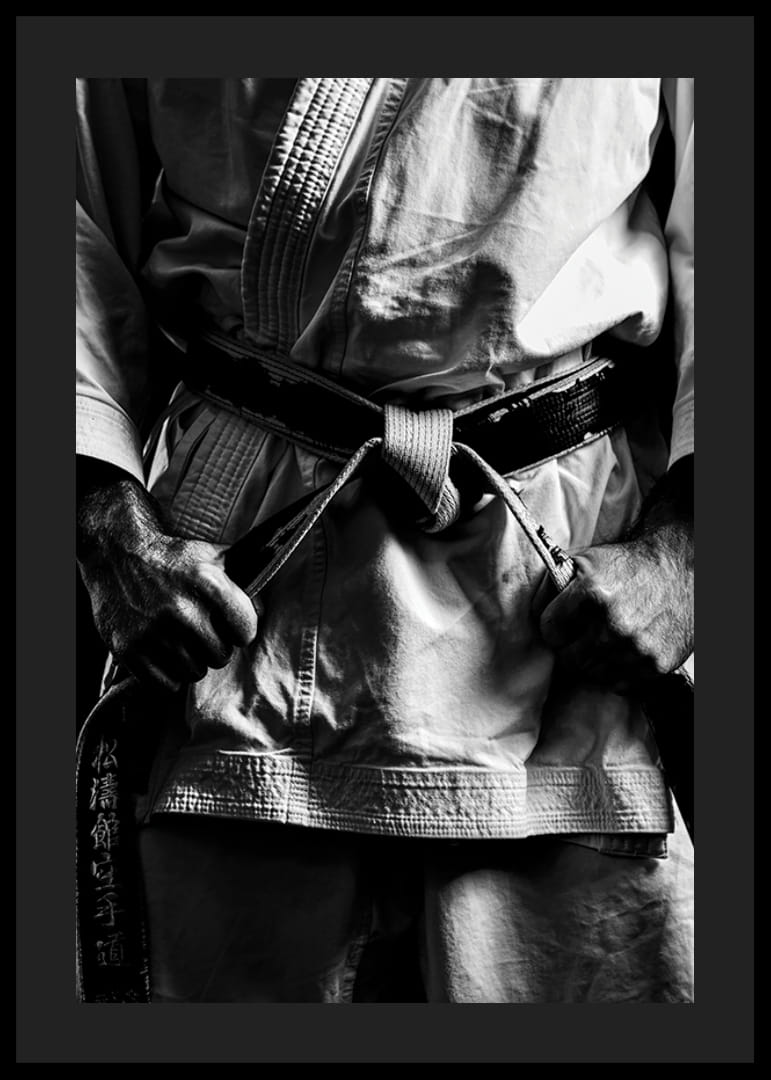 Svart-hvitt nærbilde av person i kampsportantrekk med svart belte-12