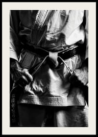 Svart-hvitt nærbilde av person i kampsportantrekk med svart belte-4