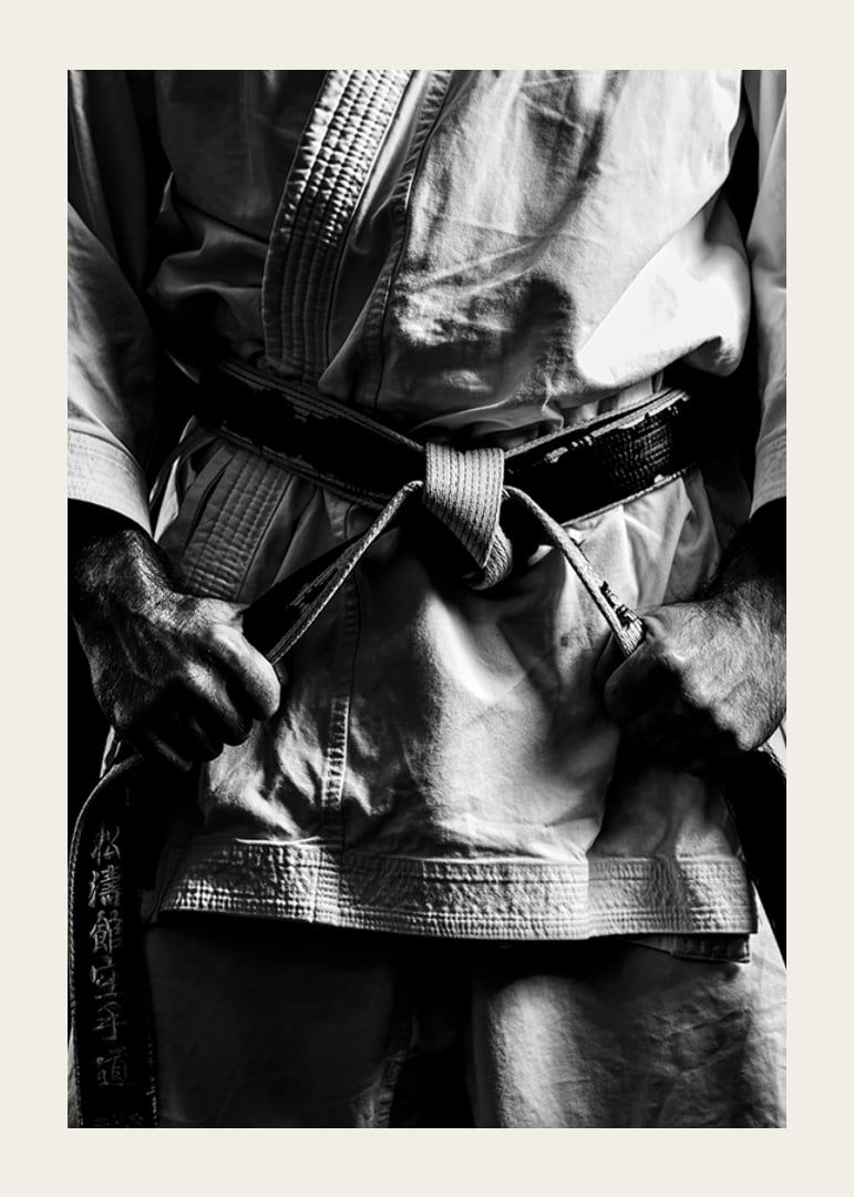 Black and white close-up of person in martial arts outfit with black belt-12
