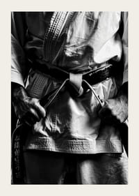 Svart-hvitt nærbilde av person i kampsportantrekk med svart belte-5