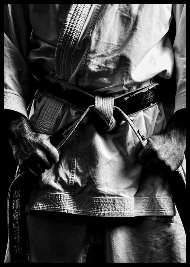 Black and white close-up of person in martial arts outfit with black belt-12