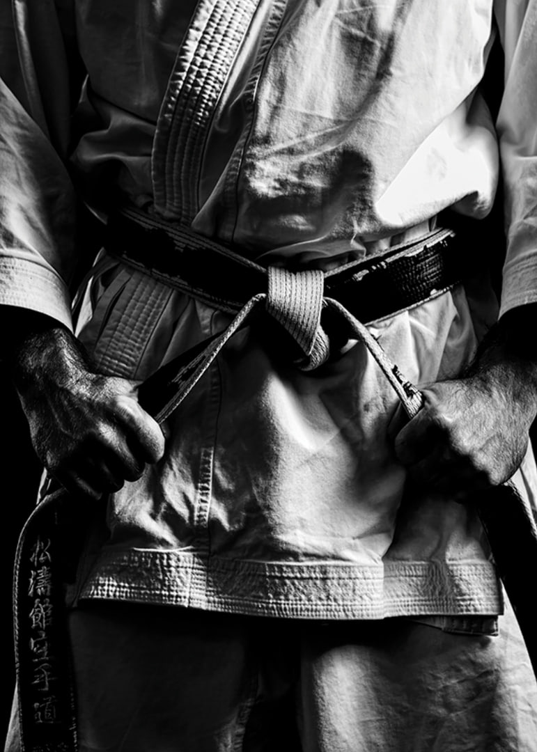 Black and white close-up of person in martial arts outfit with black belt-12