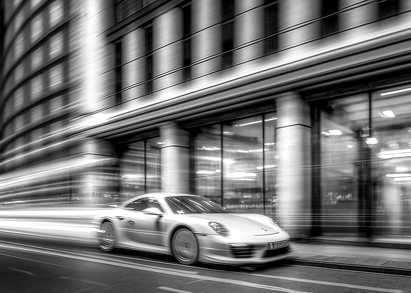 Fotografie alb-negru cu un Porsche 911 în mișcare în fața primăriei-12