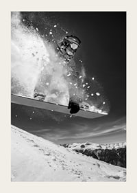 Black and white action shot of snowboarder in the middle of a jump-3