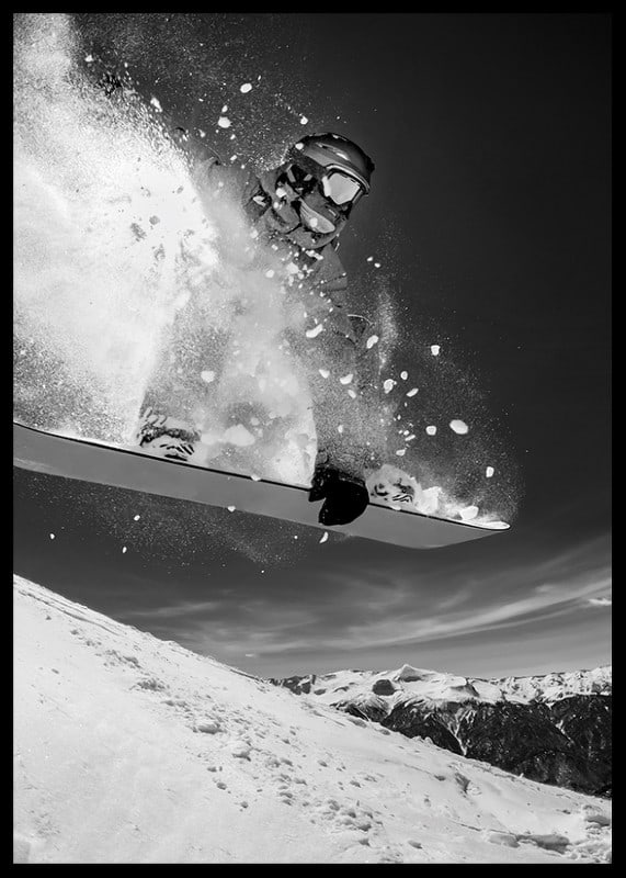 Black and white action shot of snowboarder in the middle of a jump-12
