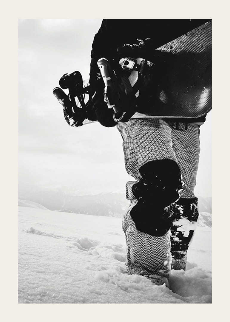 Czarno-białe zdjęcie snowboardzisty z deską na tle zaśnieżonego krajobrazu-12