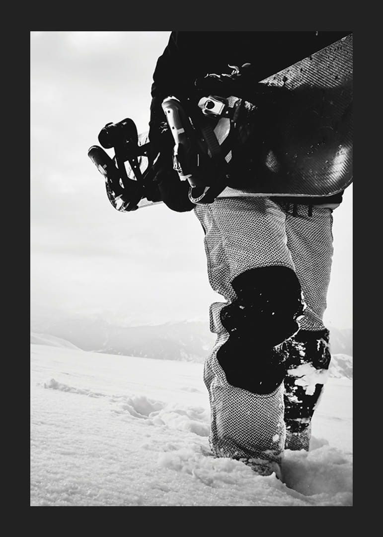 Czarno-białe zdjęcie snowboardzisty z deską na tle zaśnieżonego krajobrazu-12