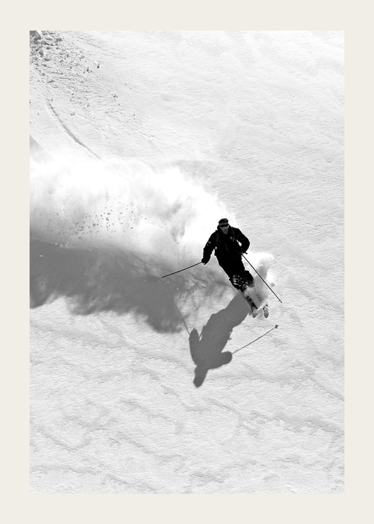 Black and white skier moving down snow-covered mountainside-12