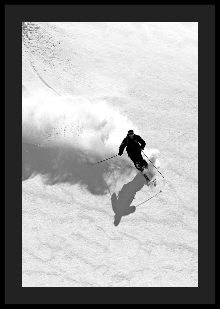 Black and white skier moving down snow-covered mountainside-12