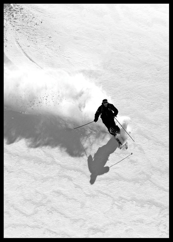 Black and white skier moving down snow-covered mountainside-12