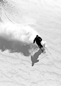 Black and white skier moving down snow-covered mountainside-7