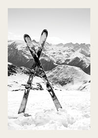 Black and white photo of crossed skis in snowy alpine landscape-3