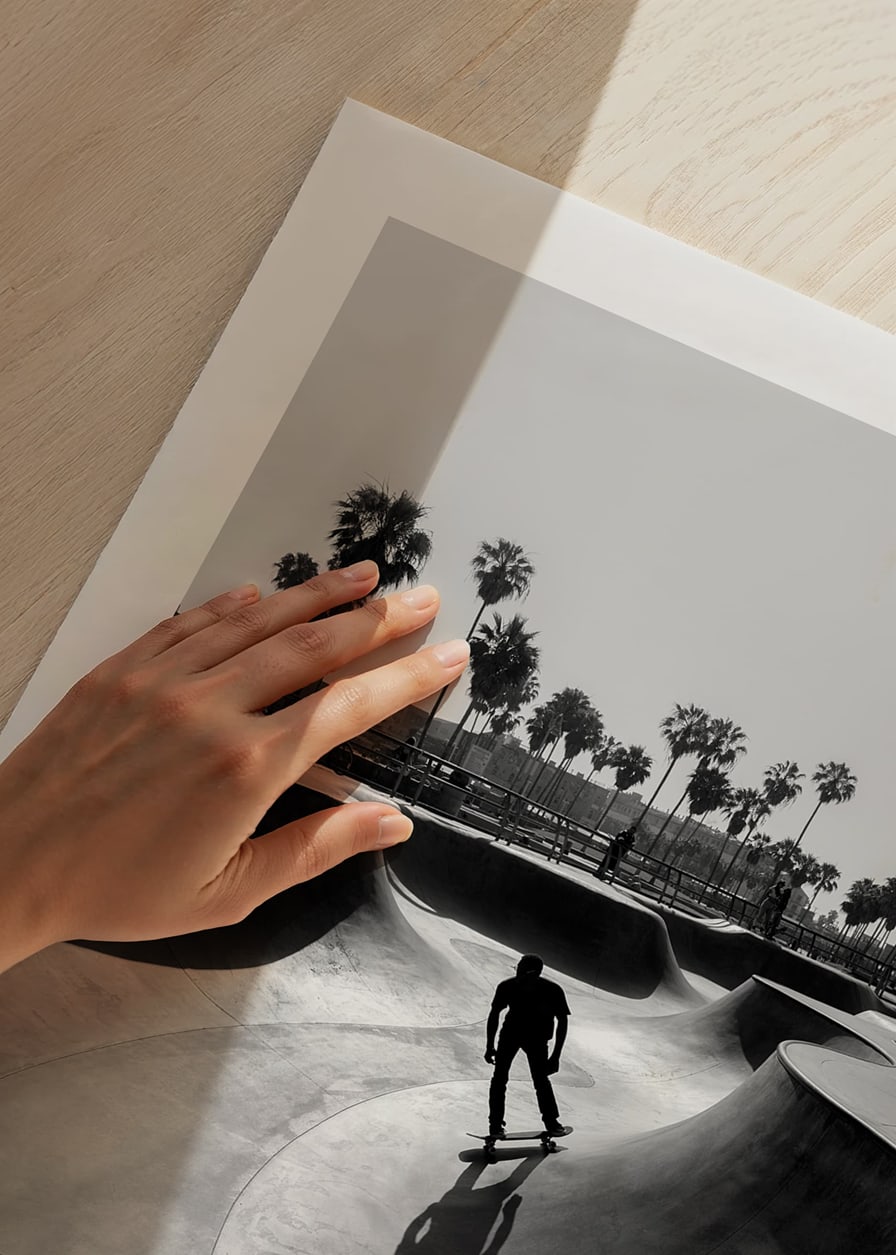 Black and white photograph of skateboarder in concrete park with palm trees-12