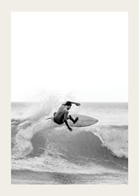 Black and white surfer caught in the middle of a wave jump-3