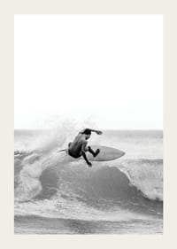 Surfista bianco e nero sorpreso nel mezzo di un salto d'onda-3