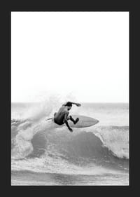 Surfista bianco e nero sorpreso nel mezzo di un salto d'onda-5