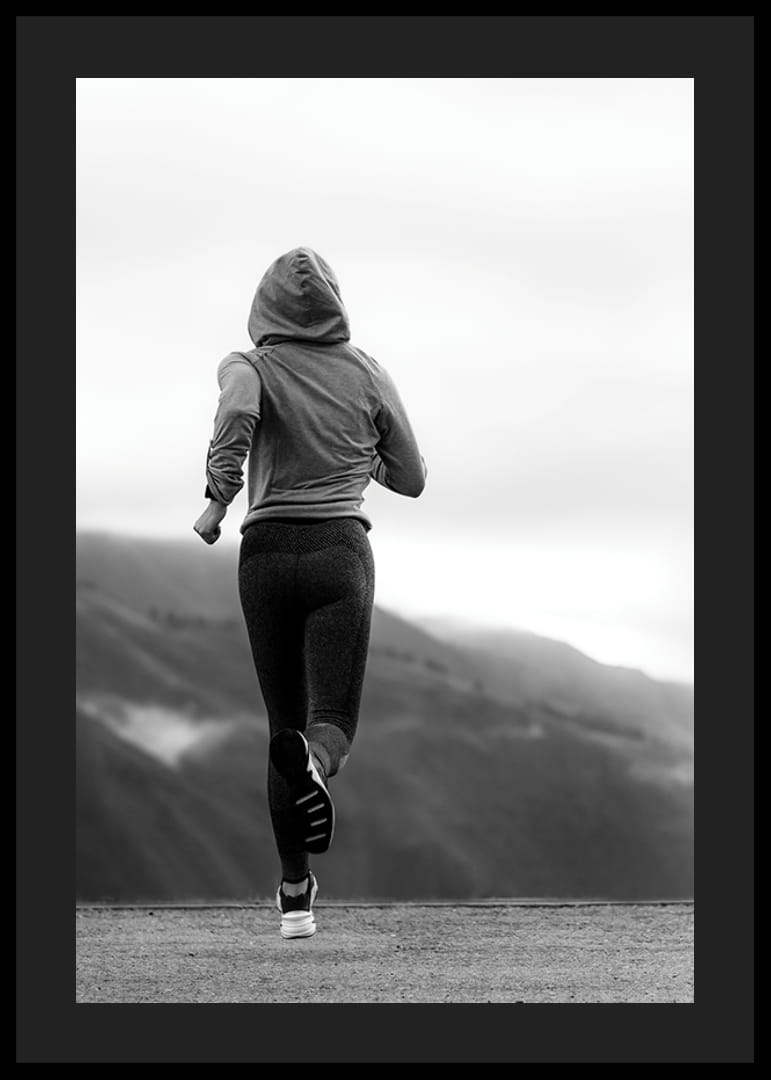 Mustavalkoisella valokuvalla kuvattu nainen juoksee ulkona vuorten taustalla-12