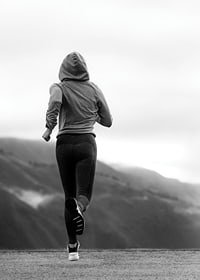 Black and white photographed woman running outdoors with mountains in the background-7