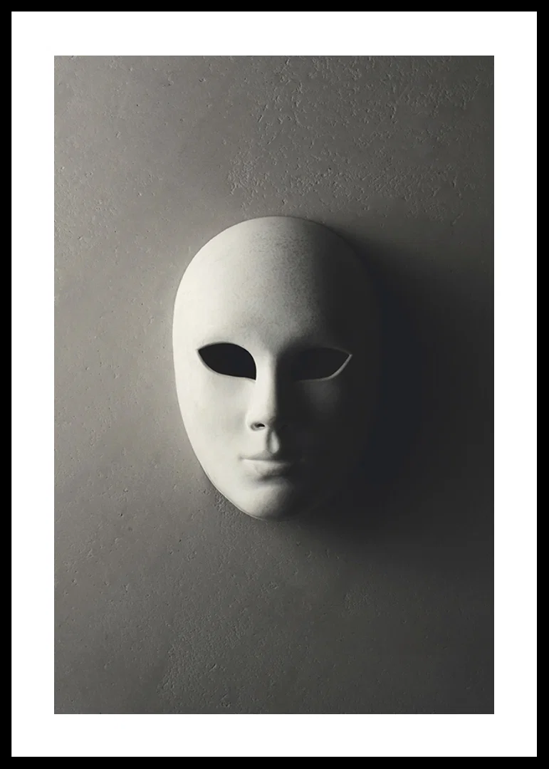 White theater mask with smooth features against gray wall in shadowy light-12