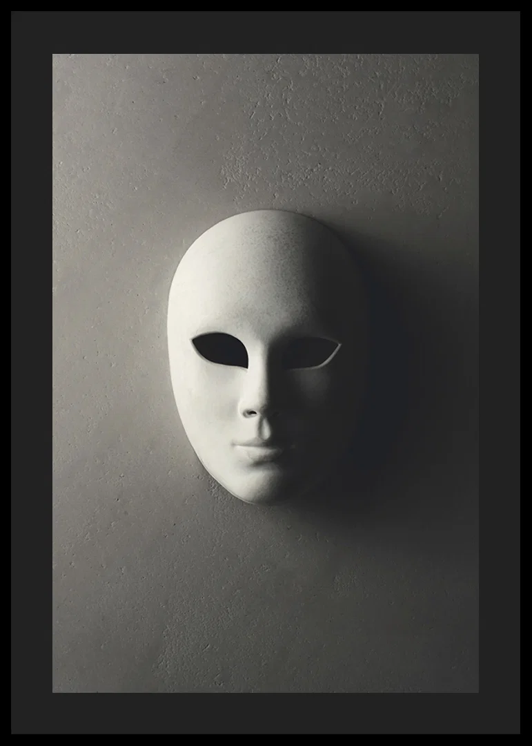 White theater mask with smooth features against gray wall in shadowy light-12