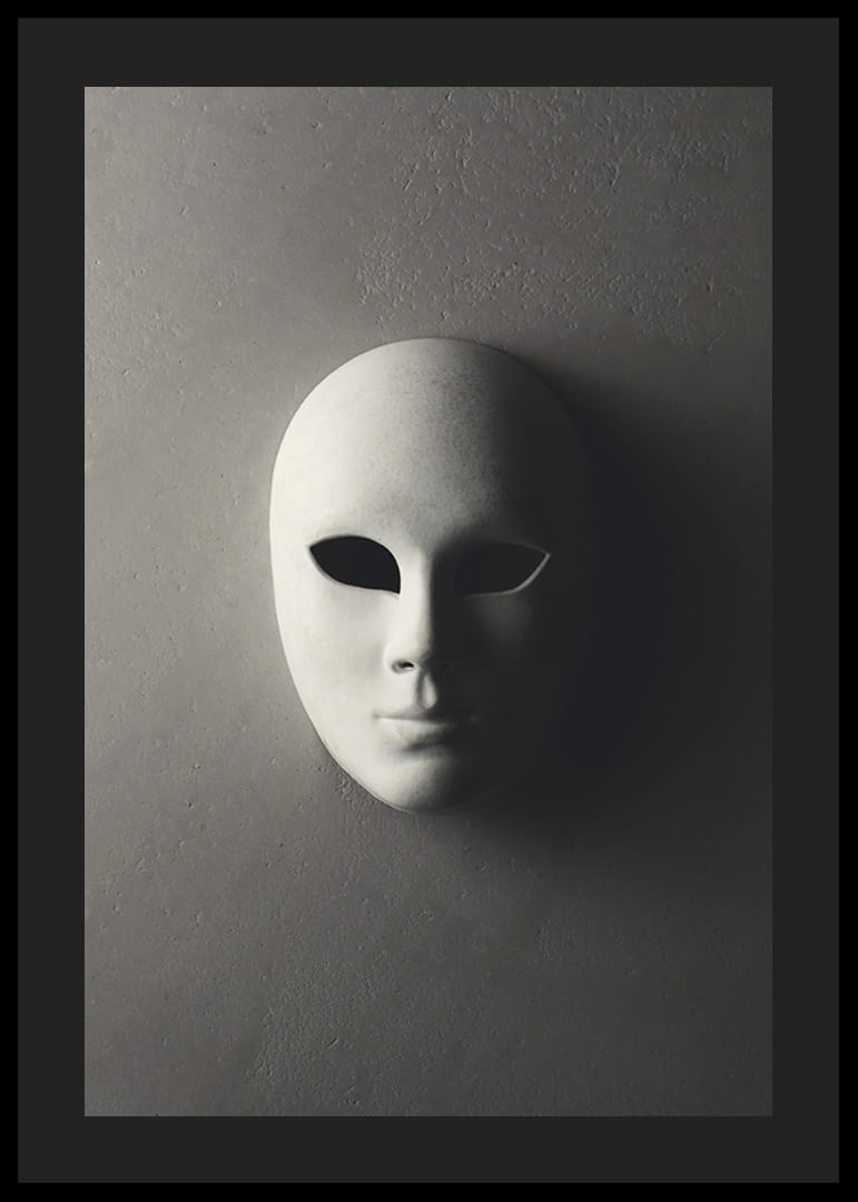 Maschera teatrale bianca con lineamenti lisci contro un muro grigio in una luce ombrosa-12