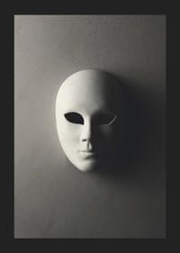 Maschera teatrale bianca con lineamenti lisci contro un muro grigio in una luce ombrosa-5