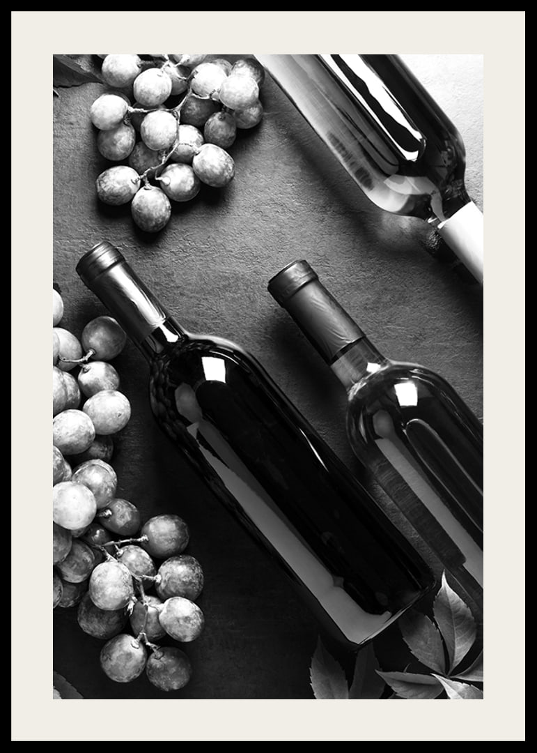 Black and white close-up of wine bottles and bunches of grapes on dark surface-12