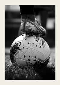 Fekete-fehér fotó egy futballcipőről, amelyet egy focilabda lábára helyeztek-5