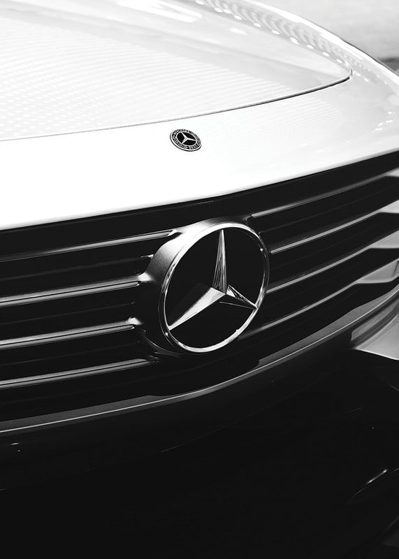Black and white close-up of Mercedes grille with emblem in focus-12