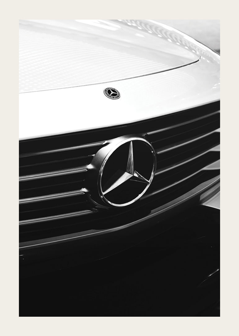 Black and white close-up of Mercedes grille with emblem in focus-12