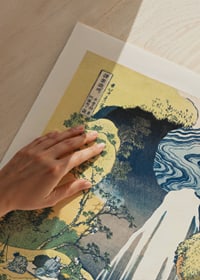Japanischer Holzschnitt eines hohen Wasserfalls zwischen Klippen und üppigen Hügeln-3