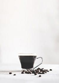 Photographic close-up of coffee glass and coffee beans, light background-7