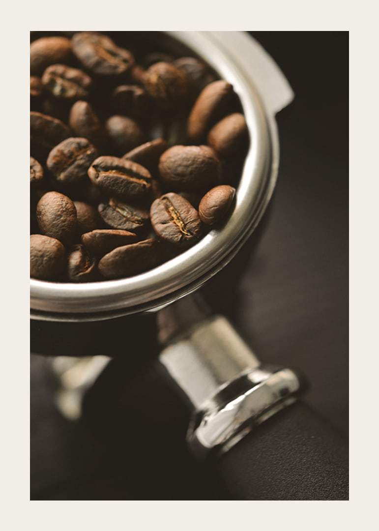 Photograph of espresso machine portafilter with coffee beans-12