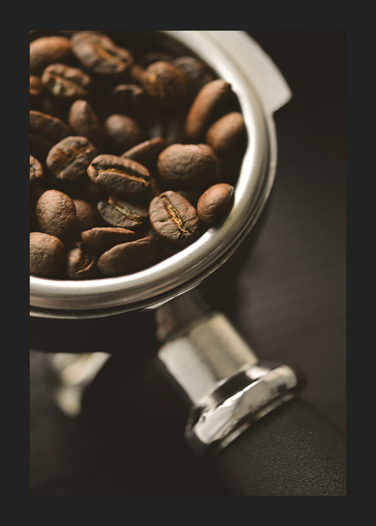 Photograph of espresso machine portafilter with coffee beans-12