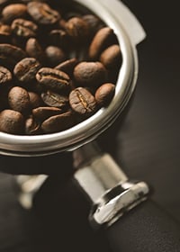 Photograph of espresso machine portafilter with coffee beans-7