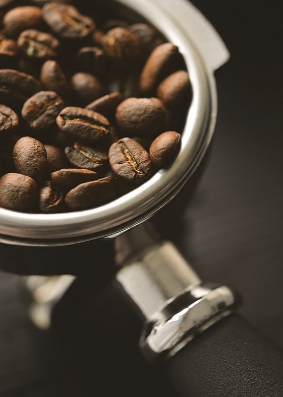 Photograph of espresso machine portafilter with coffee beans-12