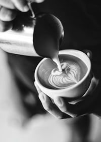 Svartvitt foto av barista som häller latteart i kopp-7