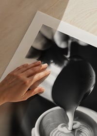 Svartvitt foto av barista som häller latteart i kopp-9