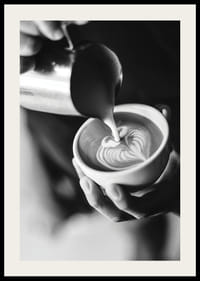 Čiernobiela fotografia baristu, ktorý nalieva latte art do šálky-2