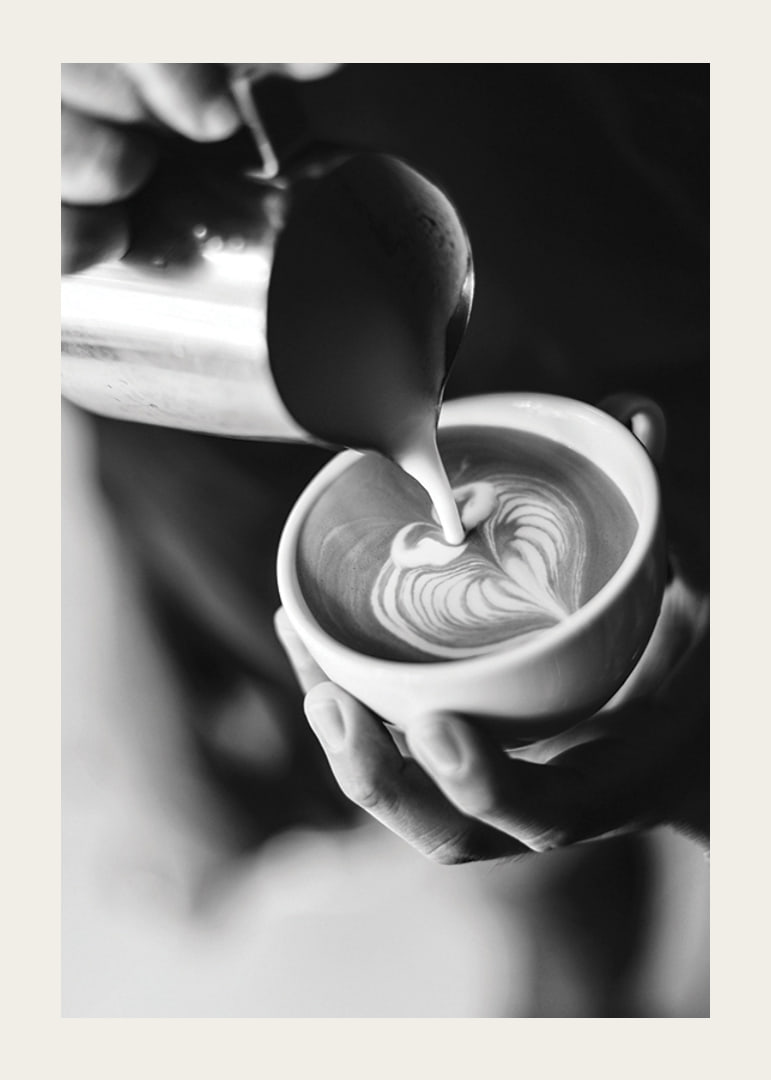 Svartvitt foto av barista som häller latteart i kopp-12